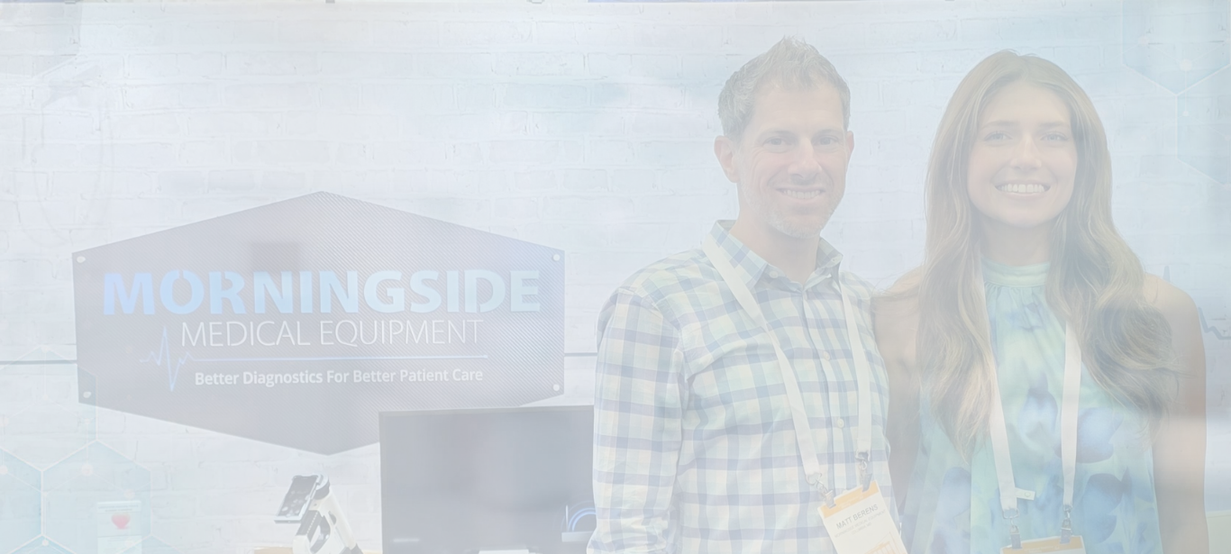 Two people smiling at the Morningside Medical Equipment conference booth banner with company sign